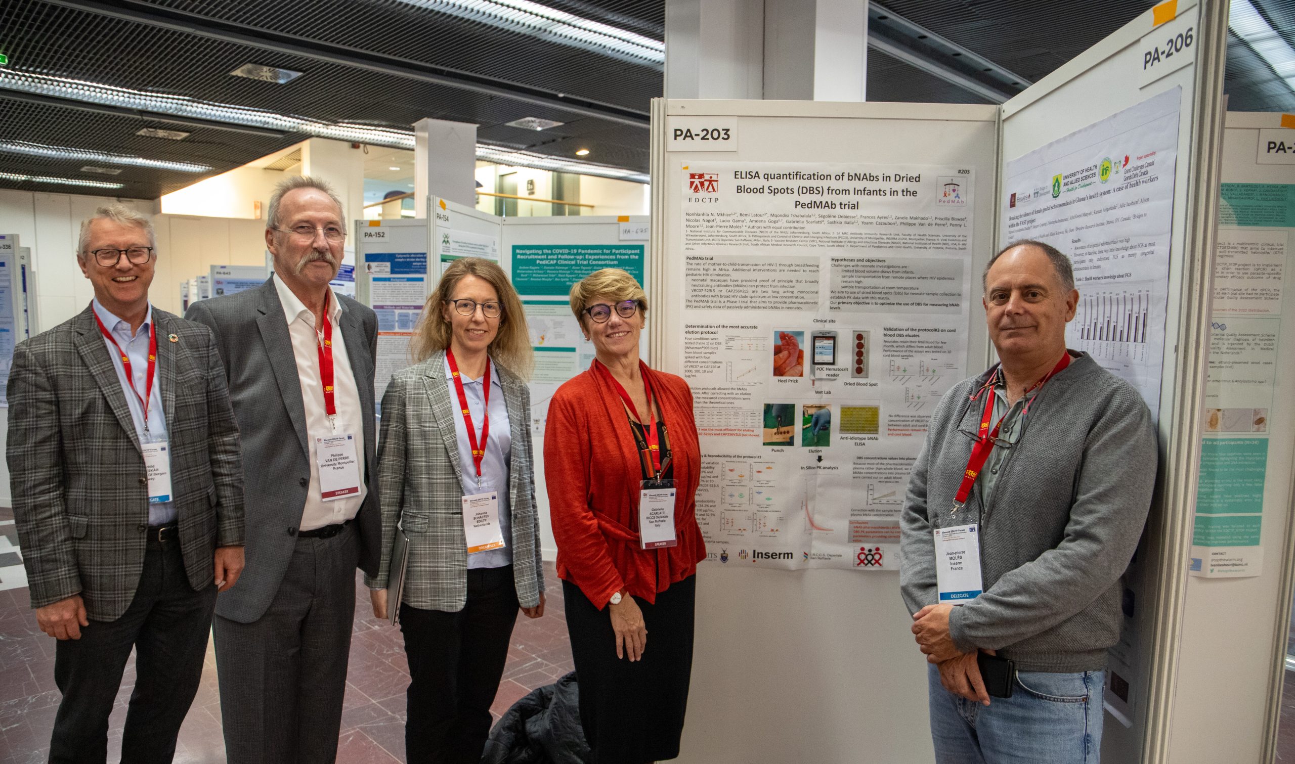 four people standing in front of scientific posters.